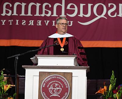 William Jay Bosanko '92 stands at the podium after receiving an honorary Doctor of Humane Letters degree.